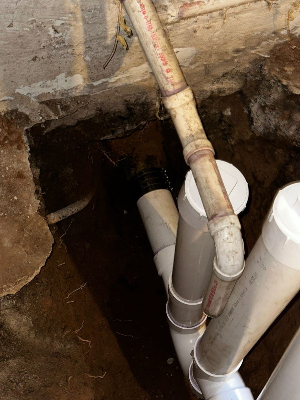 New PVC drain line installed under a basement floor after a sewer backup